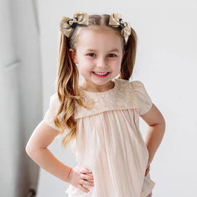 Qearl girl wearing bows at theme park, playful accessory for family outings