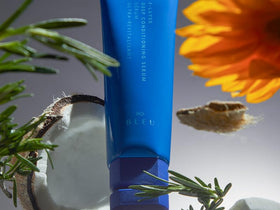 R+Co BLEU bottle in hand size comparison emphasizing compact 4.2 oz portability and value