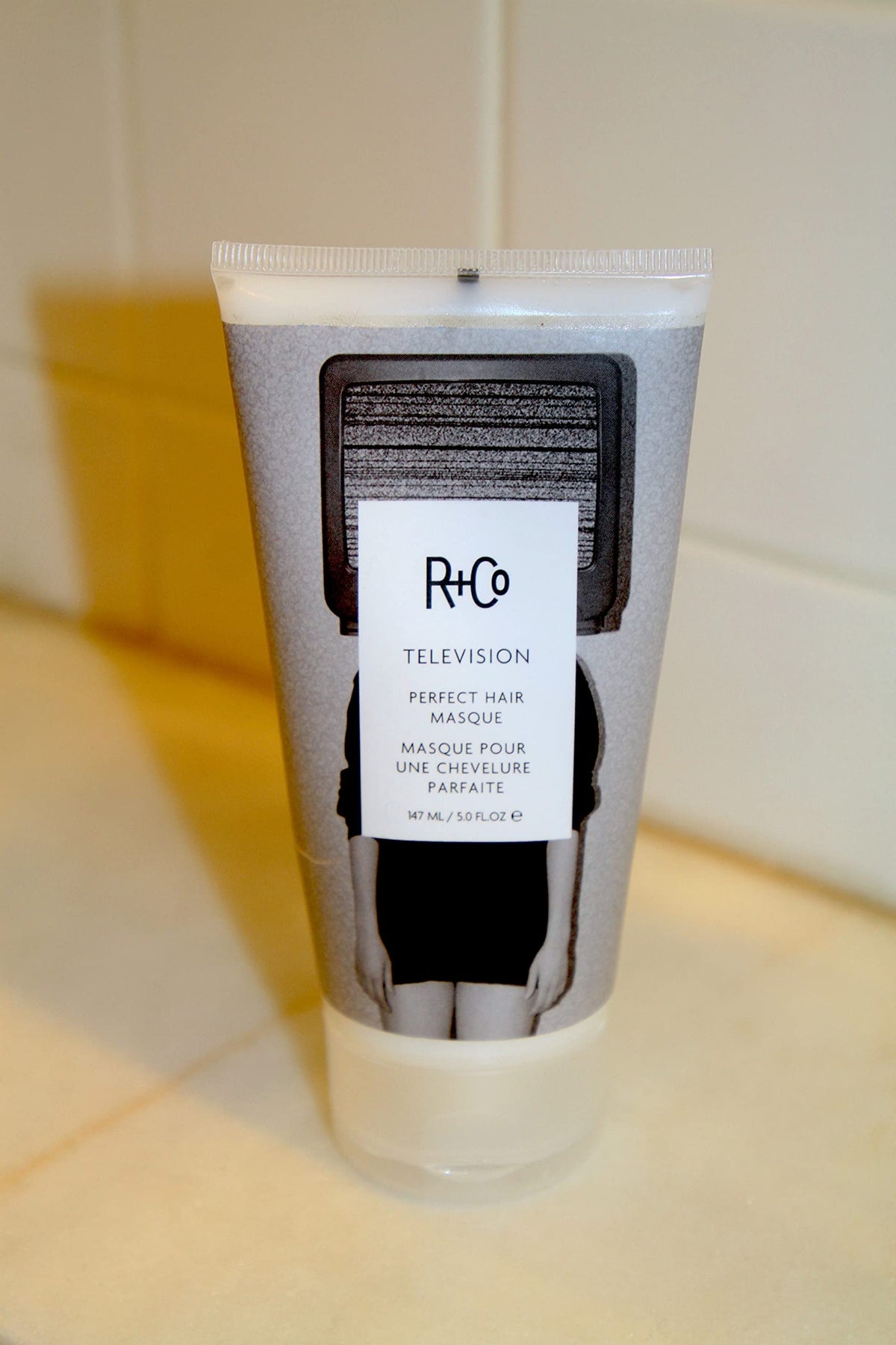 R+Co TELEVISION applied to wet hair in hand showing easy spread and detangling