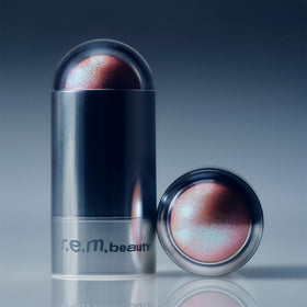 r.e.m. beauty Eclipse Glow Stick in a makeup bag flatlay conveying everyday use and portability