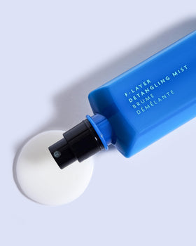 R+Co BLEU F-Layer fine mist spray close-up demonstrating even coverage and effortless detangling