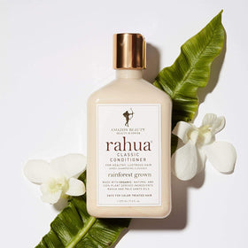 Rahua bottle held in hand showing 9.3 oz scale and travel convenience
