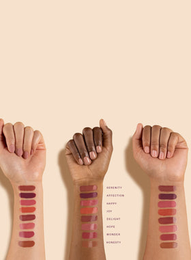 Rare Beauty Soft Pinch lip swatch on model, demonstrates vibrant color and hydrating glow