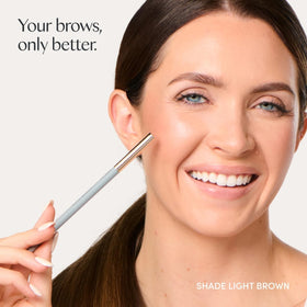 Ravie Beauty pencil held in hand to show compact travel‑friendly size