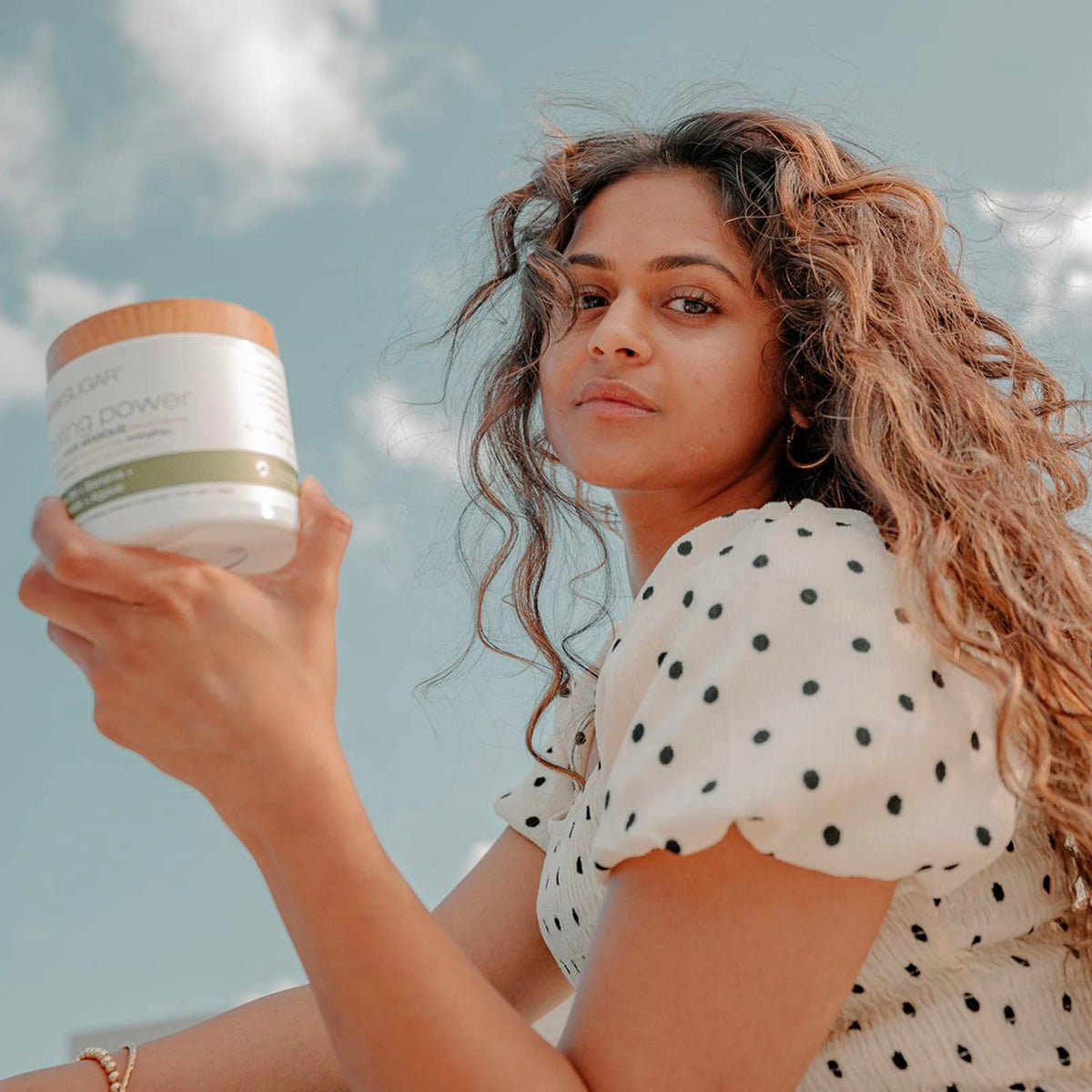 RAW SUGAR jar held in hand showing 12 oz size and travel-friendly scale