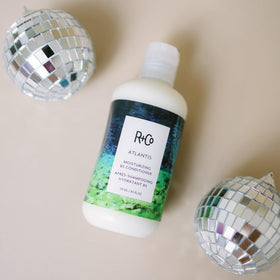 Applying R+Co ATLANTIS to hair lengths demonstrating targeted moisture benefit