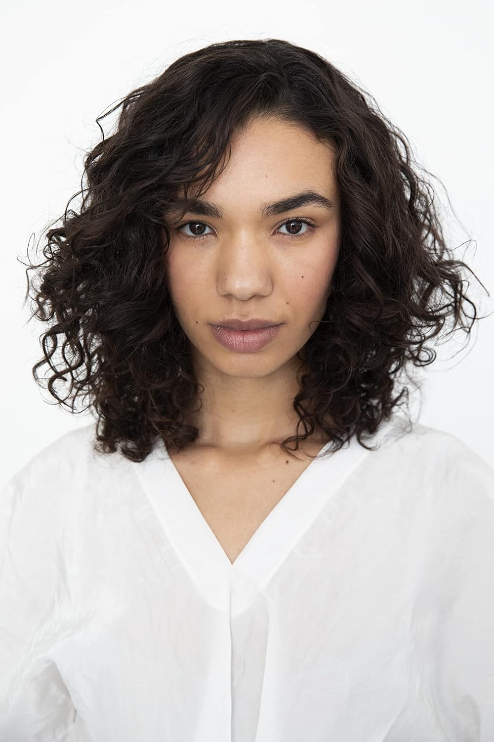 R+Co Cassette lifestyle shot on model with bouncy curls, illustrating shine