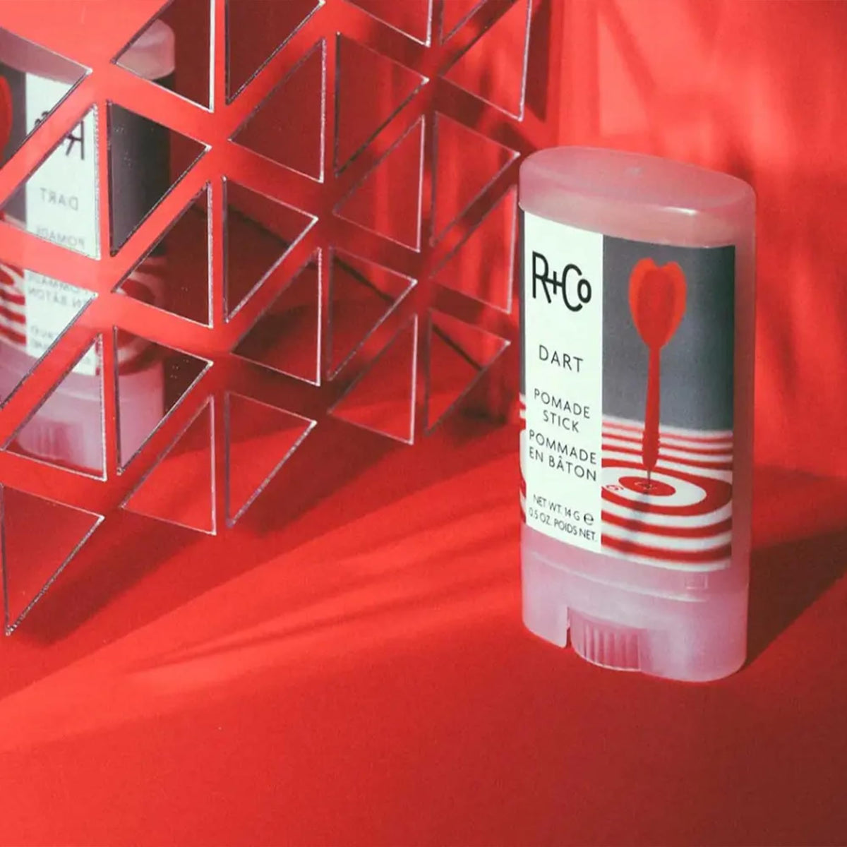 R+Co Dart Pomade Stick label close-up showing vegan and no paraben benefits