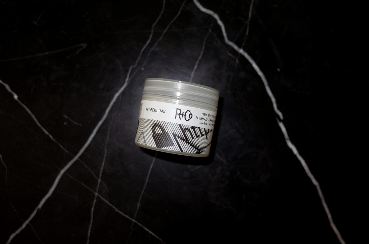 R+Co Hyperlink jar in hand to show true 2 oz scale and portability