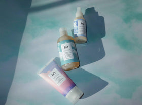 R+Co being spritzed on damp hair to illustrate detangling and blow-dry smoothing benefits