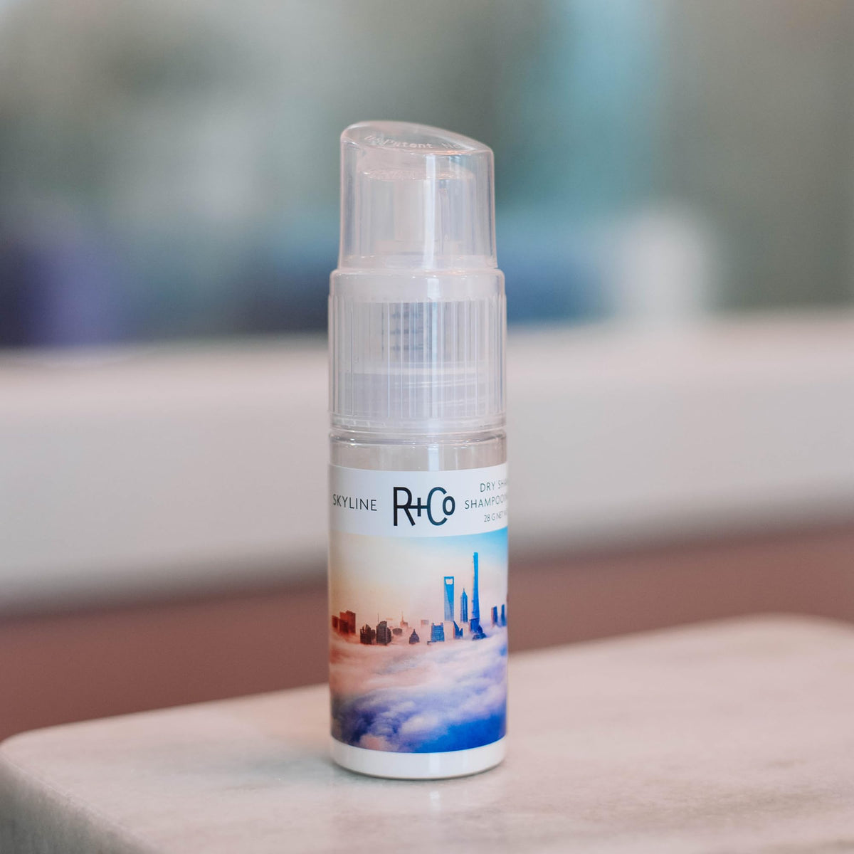 R+Co Skyline tucked into a travel bag for on-the-go oil control and freshness