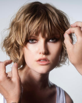 R+Co SUN CATCHER being misted onto damp hair to protect and prep for styling