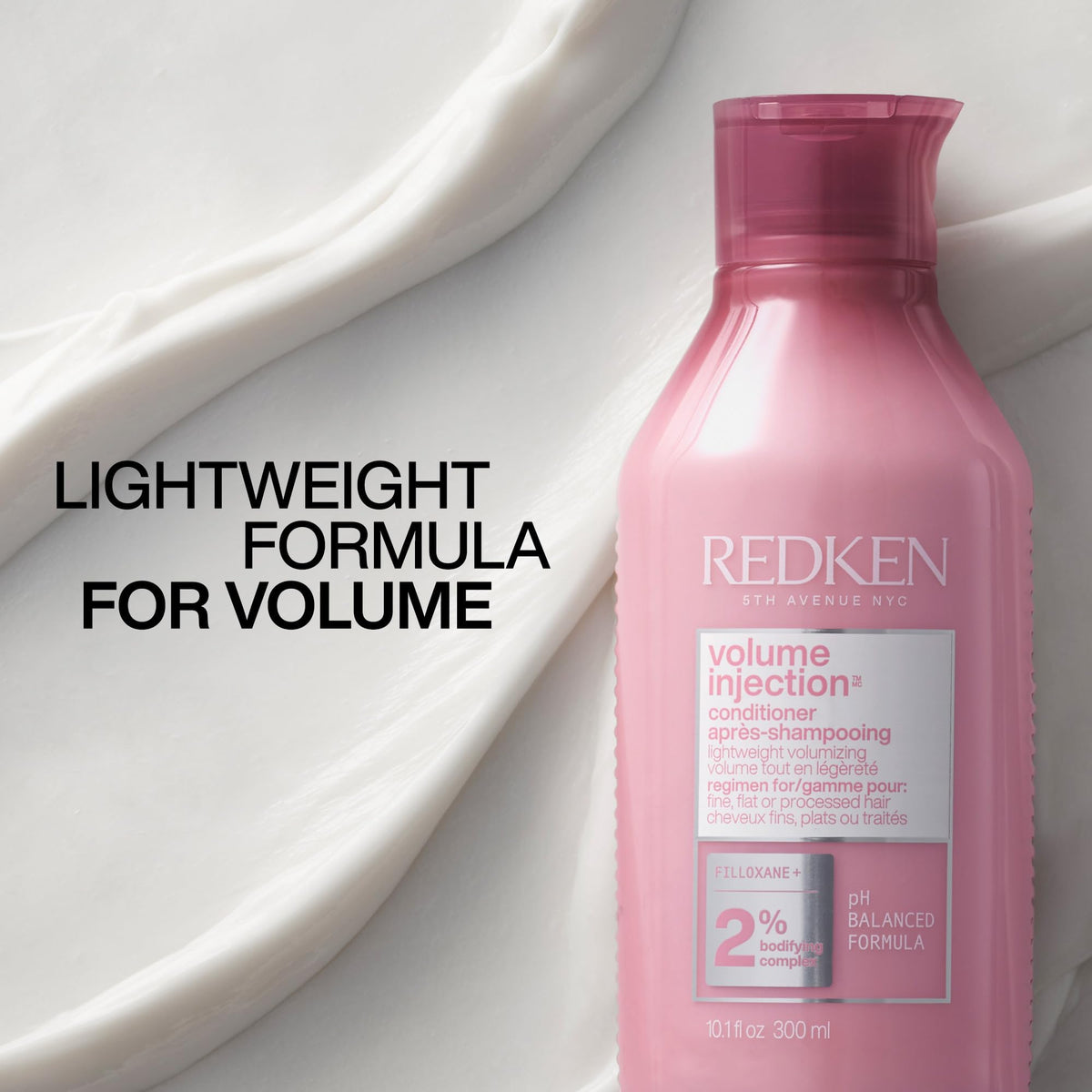 Redken bottle staged in bathroom during styling to suggest volumizing results