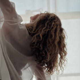 REVERIE smoothing hair into a sleek chignon demonstrating frizz control