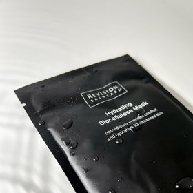 Revision Skincare serum droplet on edge of sheet highlighting concentrated hydrating essence