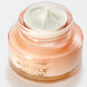 Revolution Pro cream held in hand to show size and travel-friendly benefit