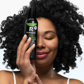 Rivermint bottle in a hand for scale, communicates travel-friendly size and convenience