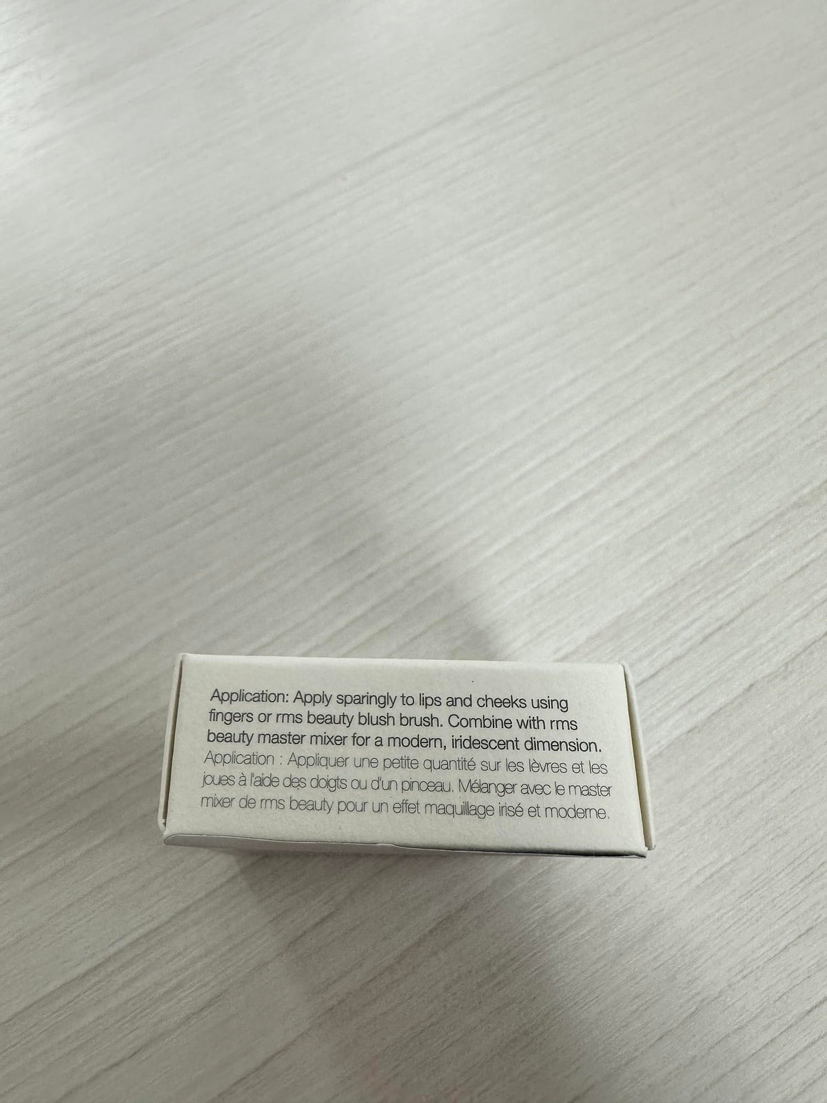 RMS Beauty next to coin for scale showing compact size and on-the-go convenience