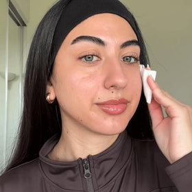 RODAN + FIELDS pouring toner into hand to show fluid consistency and easy application