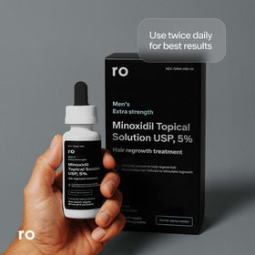 Ro ROMAN in-use photo of a man applying solution to thinning area demonstrating real-world application benefit