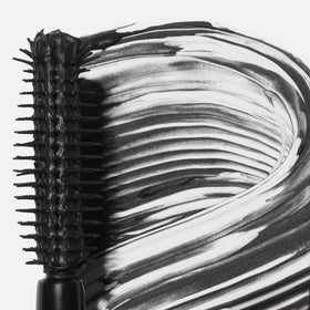 Saie mini mascara held in hand to show scale and portability for on-the-go touchups