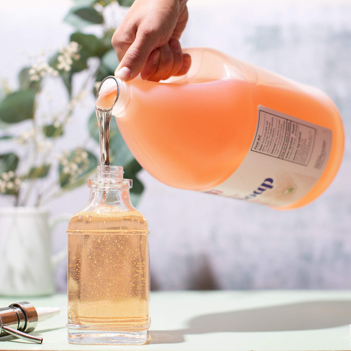 Sanit refill being poured from spout showing easy transfer and spill control