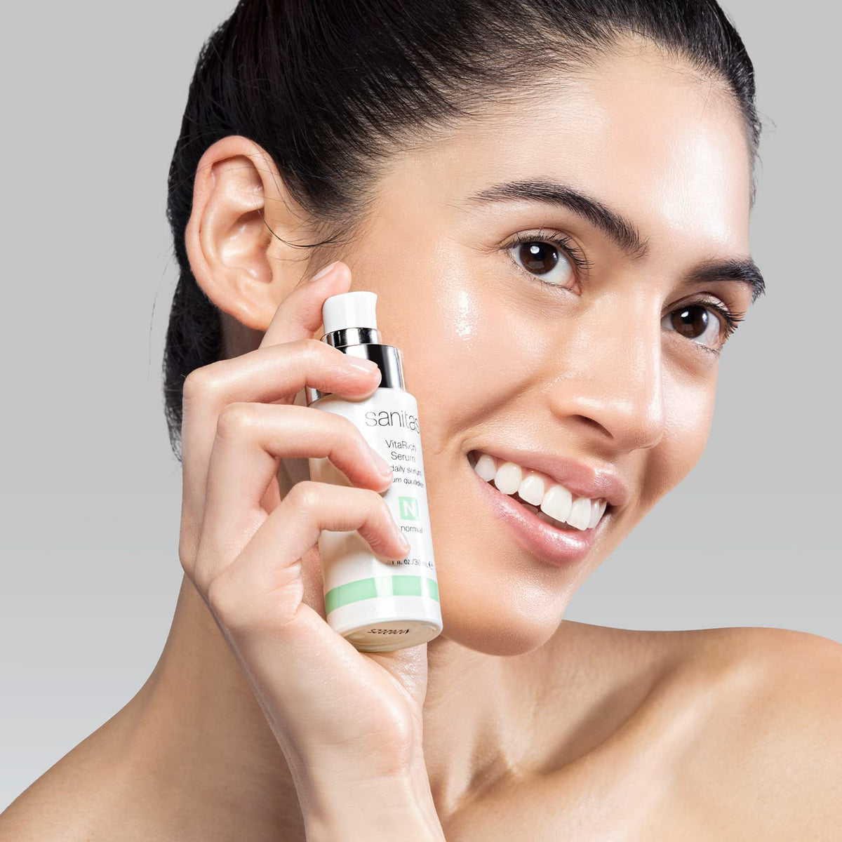 Sanitas hand applying serum to jawline showing easy layering and quick absorption