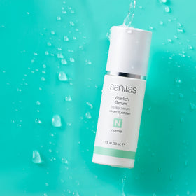 Sanitas close-up of serum texture on fingertip demonstrating lightweight absorbency