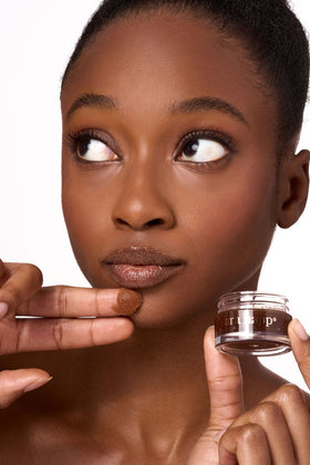 Sara Happ applying scrub to lips demonstrating gentle massage and instant smoothing benefit