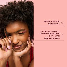 Shea Moisture shampoo applied to curly hair in shower showing effective cleansing action