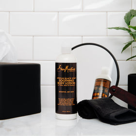 SheaMoisture hand holding bottle to show 13 oz size and practical portability