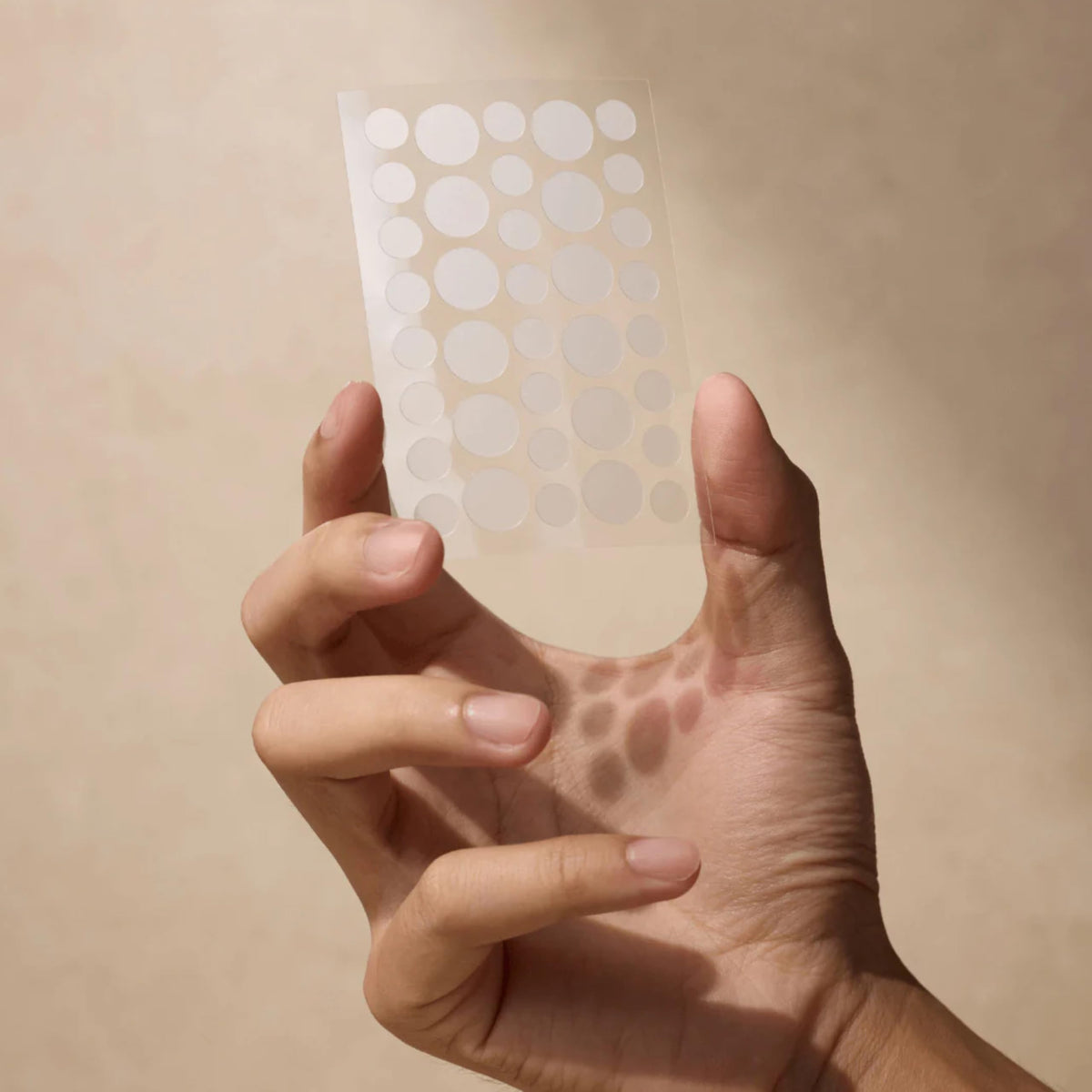 Shield patch applied to a cheek in use, showing invisibility and calming benefit on a blemish
