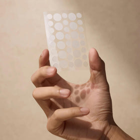 Shield patch applied to a cheek in use, showing invisibility and calming benefit on a blemish