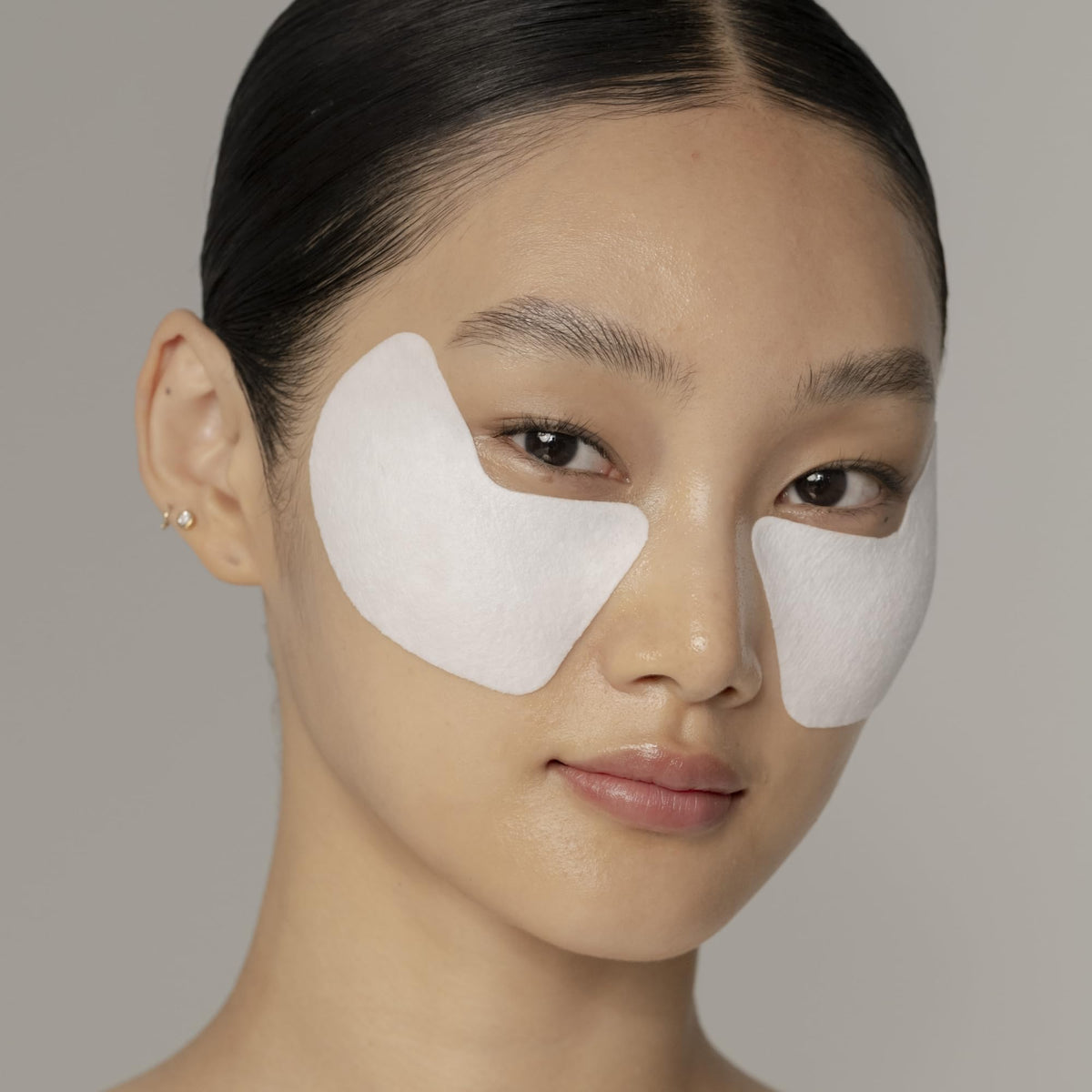 Shiseido model applying under-eye mask demonstrating correct placement and lift