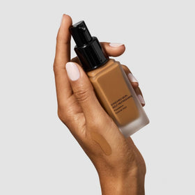 Shiseido bottle in a makeup bag on desk showing daily-wear convenience benefit