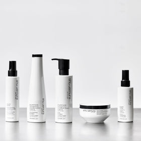 shu uemura bottle styled on bathroom shelf to show lifestyle use and elegant packaging