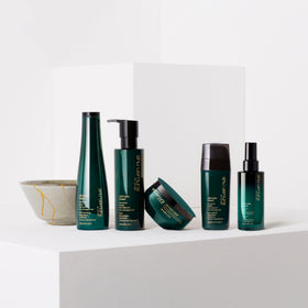 shu uemura bottle next to hand showing true 8 fl oz size and scale