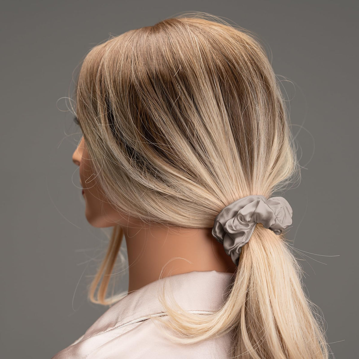 Silmer scrunchie held in hand to show true size and stretch for scale