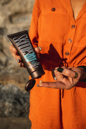 Model applying Skinnies Sungel to face showing clear, non-greasy finish