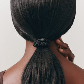 SLIP scrunchie beside SLIP pillowcase, matching silk protects hair while sleeping