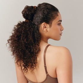 SLIP scrunchie beside a coin to show slim size and travel-friendly scale