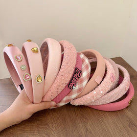 Sluxa pink headband next to ruler showing scale and everyday practicality