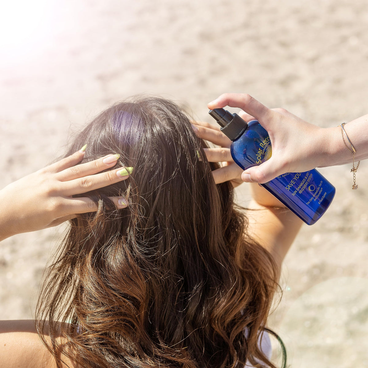 Solar Recover hair spray being applied to wet hair to ease knots and frizz