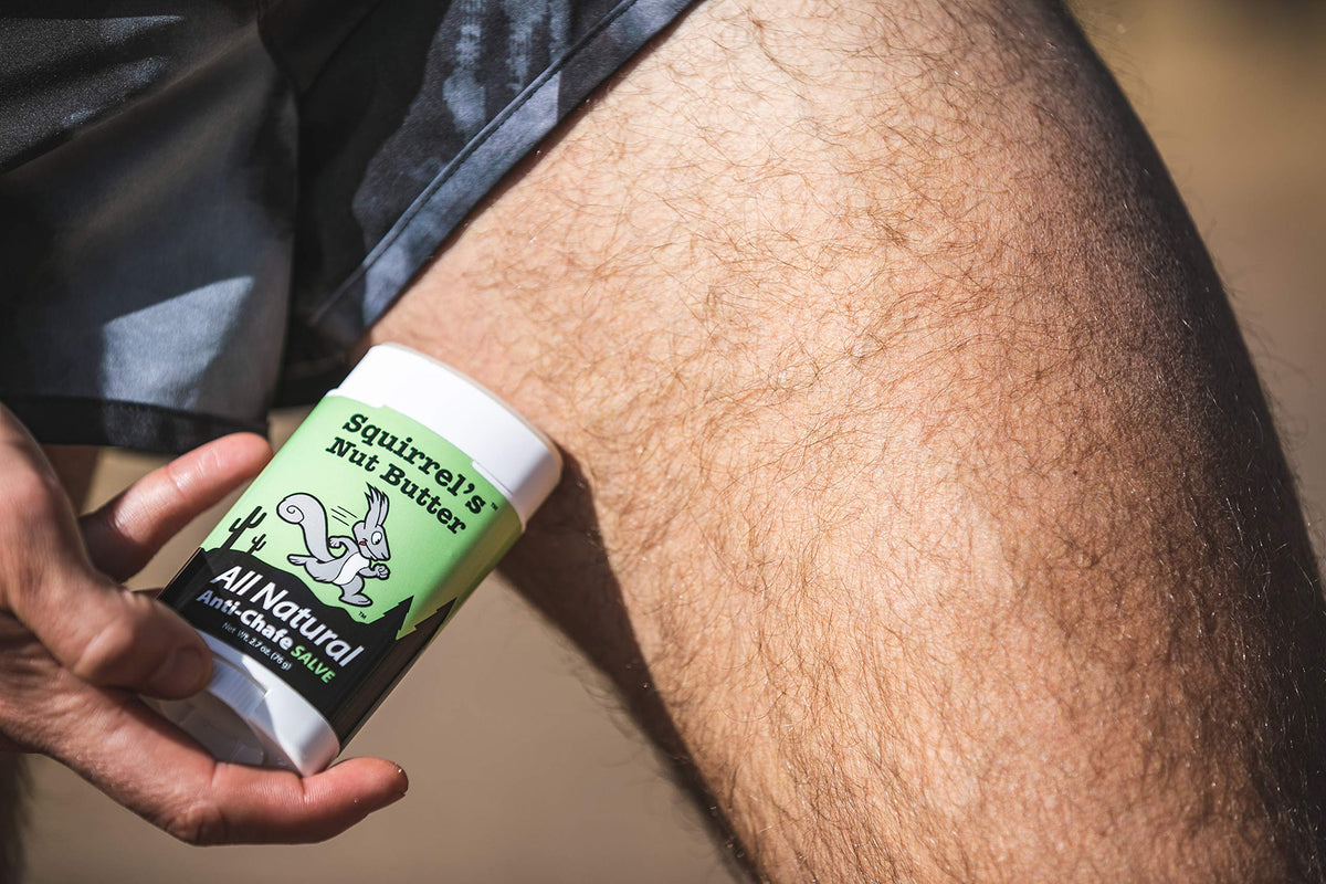 Runner applying Squirrel's Nut Butter to inner thigh to prevent chafing