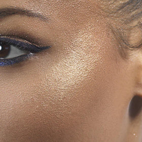 stila highlighter inside a makeup bag staged with brushes for on-the-go touch-ups and polished glow
