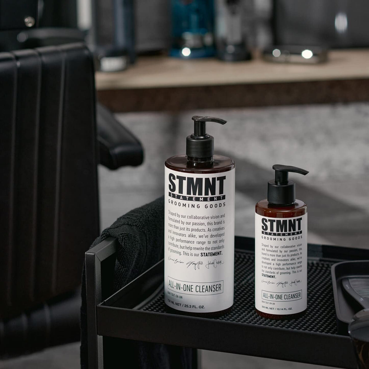 STMNT bottle beside hand showing 10.1 oz scale for travel convenience benefit