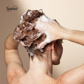 Suave bottles held in hand showing 22.5 oz family-sized convenience