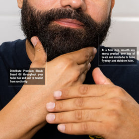 Man smoothing beard with Suavecito oil illustrating softer, more manageable hair