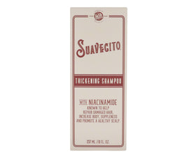 Suavecito set on bathroom shelf next to styling tools showing fuller-look hair routine benefit