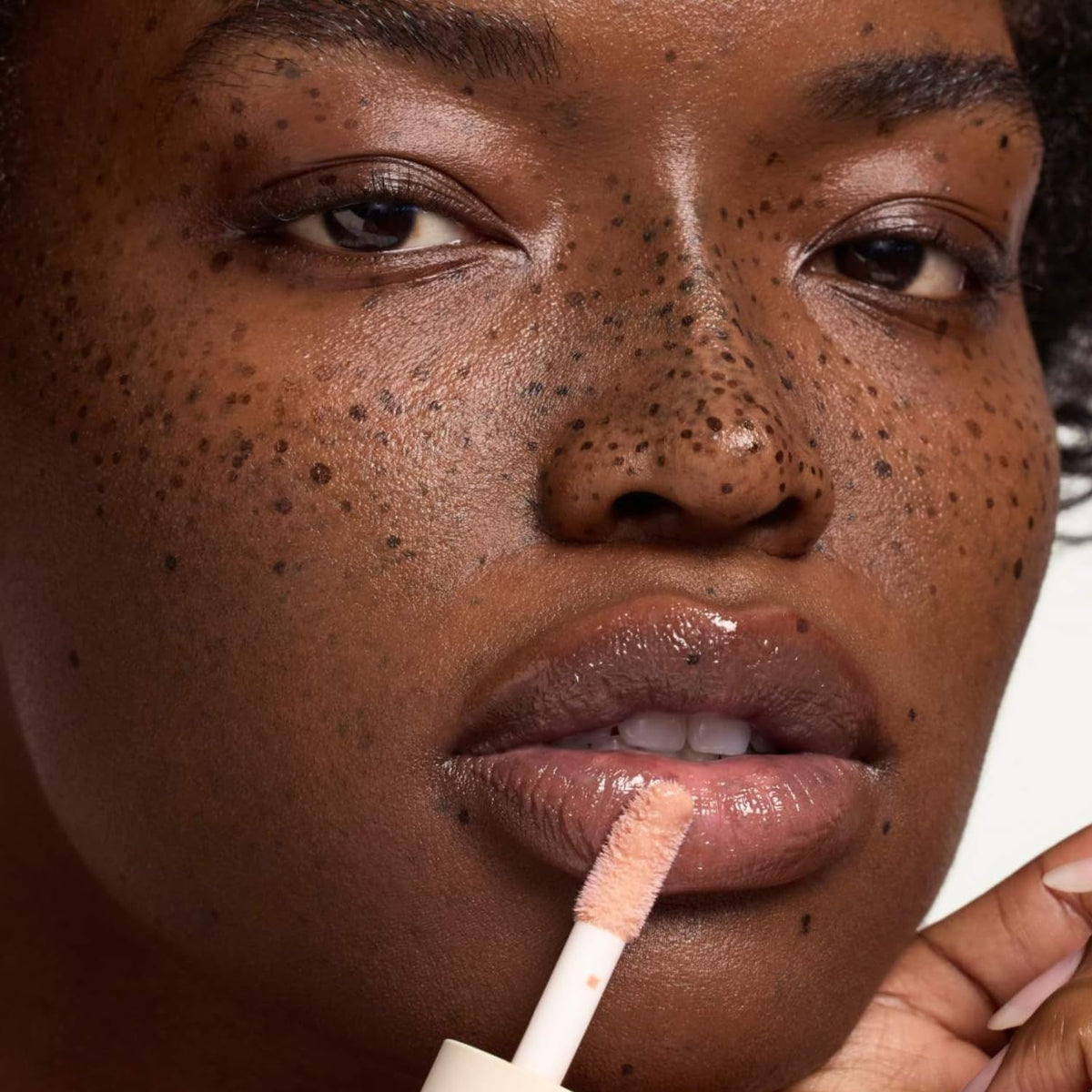 Summer Fridays lip oil layered over lipstick showing added gloss and dimension